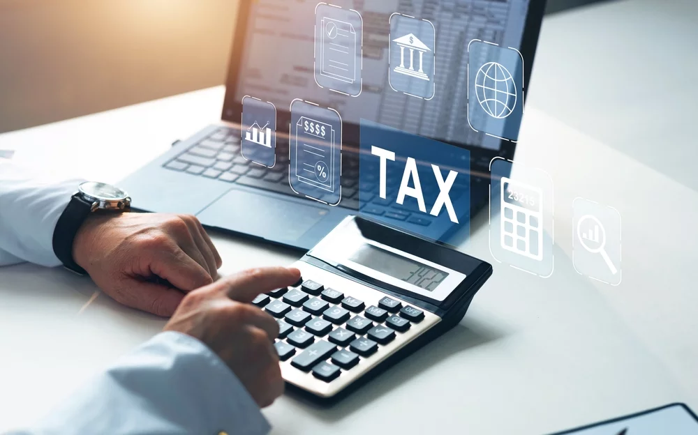 Perintöverotusta havainnollistava kuva laskimesta ja tietokoneesta.