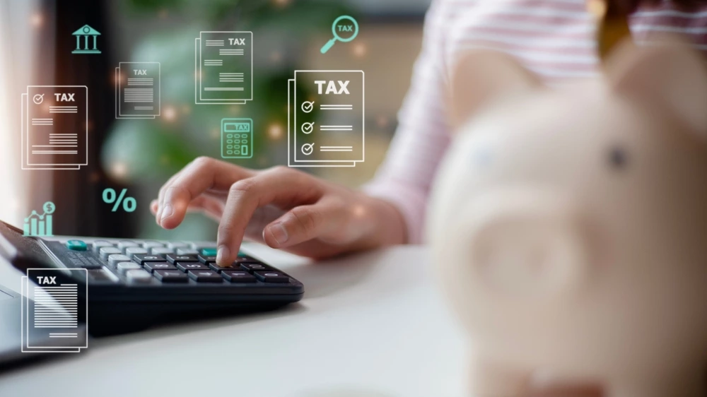 Perintöveron laskemista havainnollistava kuva laskimesta ja tietokoneesta